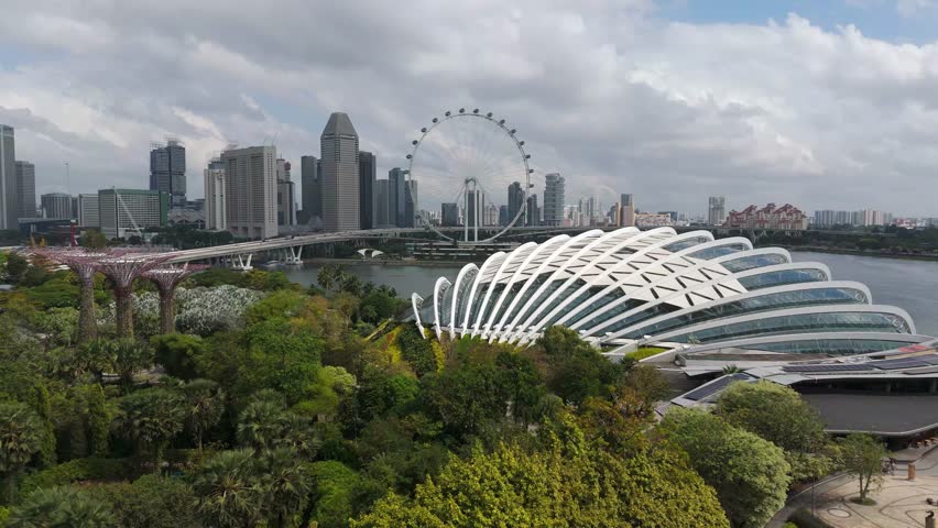 Gardens By the Bay, Singapore Flyer, skyline and iconic artscience Museum in Singapore. Aerial forward wide shot. Skyline with skyscrapers in distance.