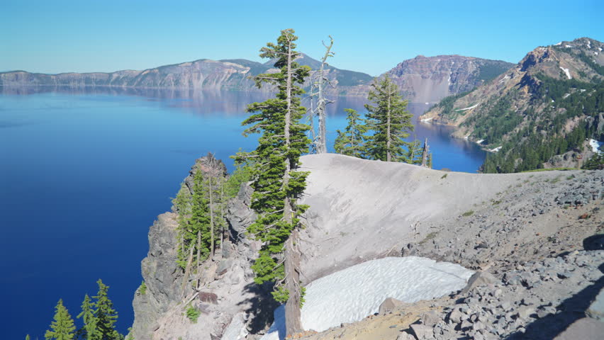 Crater Lake, Oregon, clear skies, blue waters, rugged cliffs, green trees, peaceful view