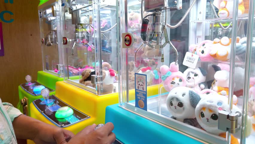 Claw machine full of plush toys in bright colors, playful and fun indoor arcade scene
