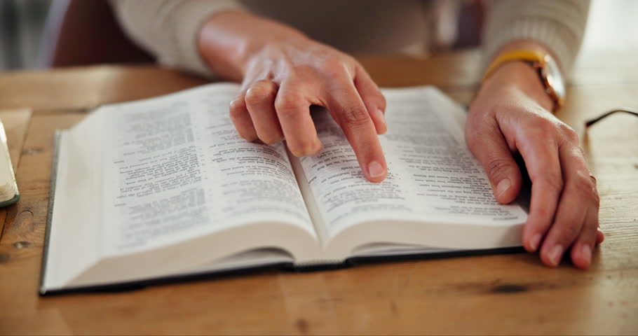 Hands, book and bible study in home for religion, peace or learning on spiritual journey in morning. Person, research or scripture for worship in house, gratitude and search for inspiration in gospel