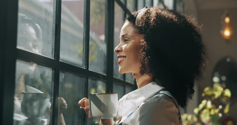 Coffee, thinking and happy woman by window with ideas, inspiration and daydreaming in home. Relax, morning and person in living room with drink for reflection, wellness and satisfaction on weekend