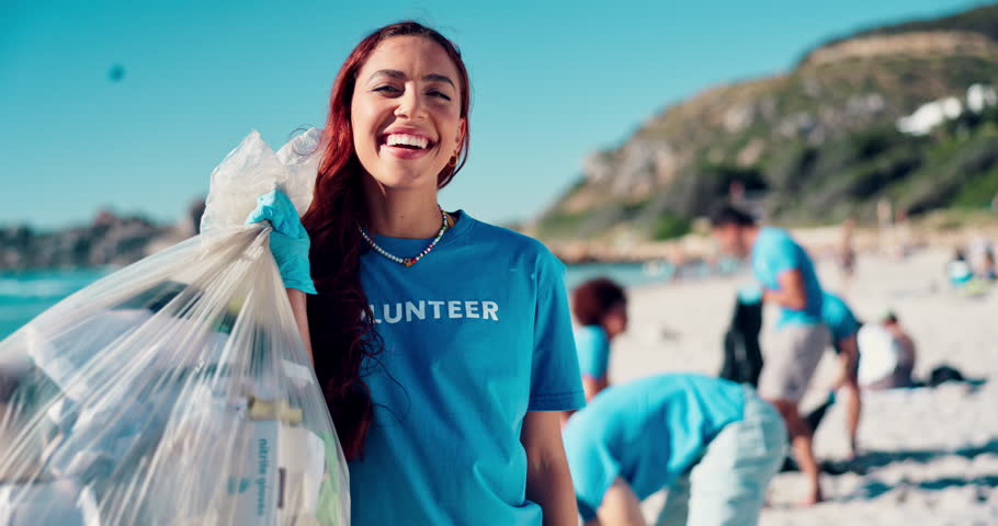 Volunteer, cleaning and face with plastic bag at beach for trash collection, coastal litter and sustainability. NGO project, girl and community service for environment conservation or waste recycling