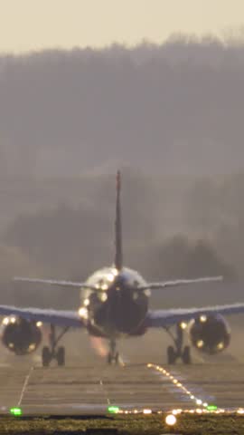 Passenger plane takes off at sunset. Vertical video