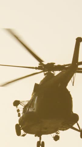 Military helicopter landing at sunset from the airbase runway