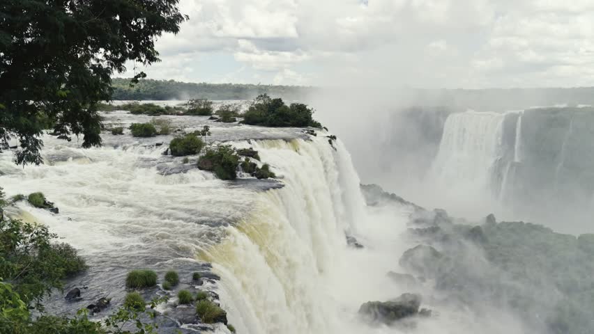 Panoramic view of Devil´s throat, Iguazu Falls from the Brazilian side with a wooded landscape a cloudy day.