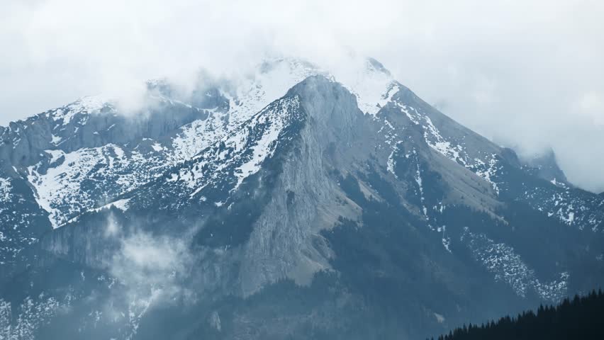 Cloudy weather in the mountains. Clouds over the rocks, timelapse.