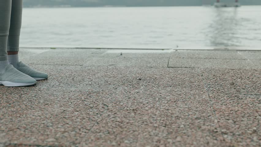 A fitness trainer aids a sportive black woman during a weightlifting session, focusing on deadlifts with dumbbells.