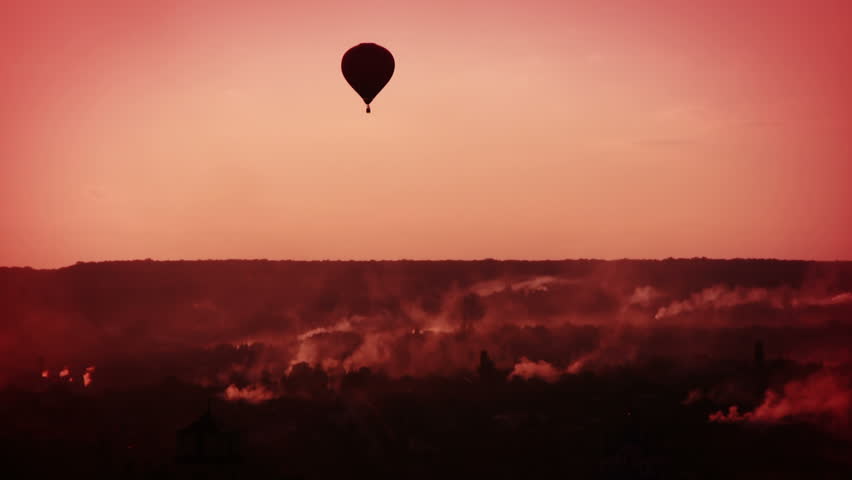 Early morning. The smoke from the chimneys of private homes. Air balloon flying