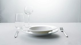 Elegant table setting with white tableware plates, cutlery, and glassware for a classy dining, fancy expensive restaurant dinner - Powered by Shutterstock - Get 15% off with code: PIKWIZARD15