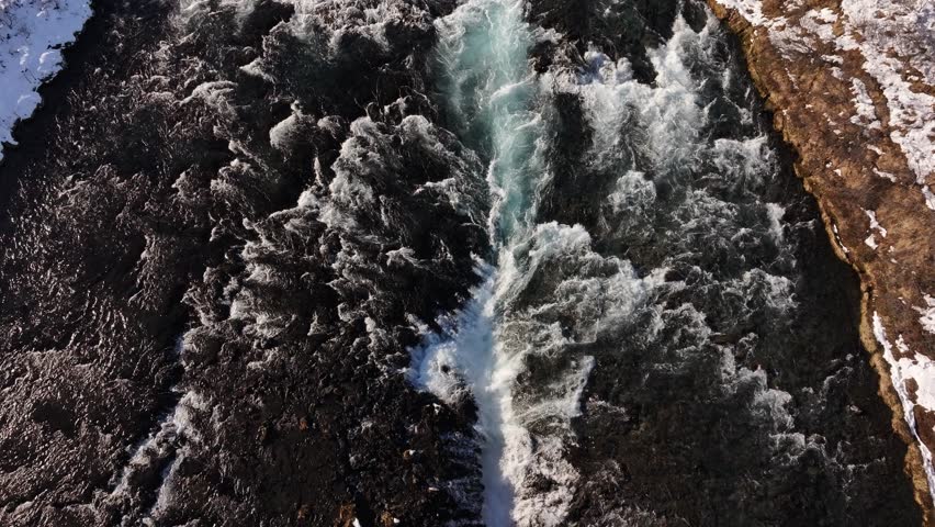 Snowy Brúarfoss waterfall with rapid streams, aerial view in Laugarvatn, Iceland