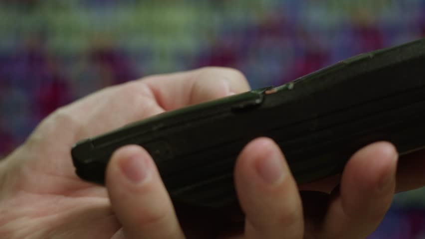 80s 90s retro vintage cell phone being used by a young adult woman, taking old mobile phone with antenna from jeans pocket.