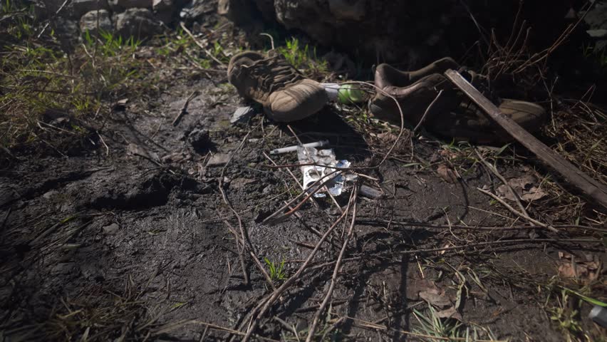 Discarded litter with drug use evidence on neglected urban wasteland