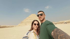 Tourists couple taking selfie at the step pyramid of djoser - Powered by Shutterstock - Get 15% off with code: PIKWIZARD15