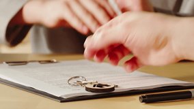 Customer signing contract, real estate agent giving home keys close-up, woman realtor. Buying flat apartment, property purchasing. Moving to new house, housing service concept. - Powered by Shutterstock - Get 15% off with code: PIKWIZARD15