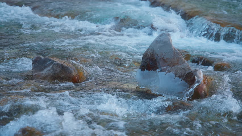 Mountain river stream cascading between the rocks. Slow motion.