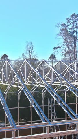Construction workers are assembling metal framed warehouse in location under works area