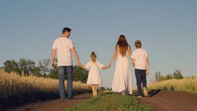 Happy family walking through wheat field holding hands. Mom dad children son daughter enjoying nature in summer in rural area. Parents farmers children boy girl, teamwork. Family business education - Powered by Shutterstock - Get 15% off with code: PIKWIZARD15