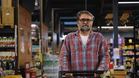 Senior man pushing shopping cart in supermarket aisle - Powered by Shutterstock - Get 15% off with code: PIKWIZARD15
