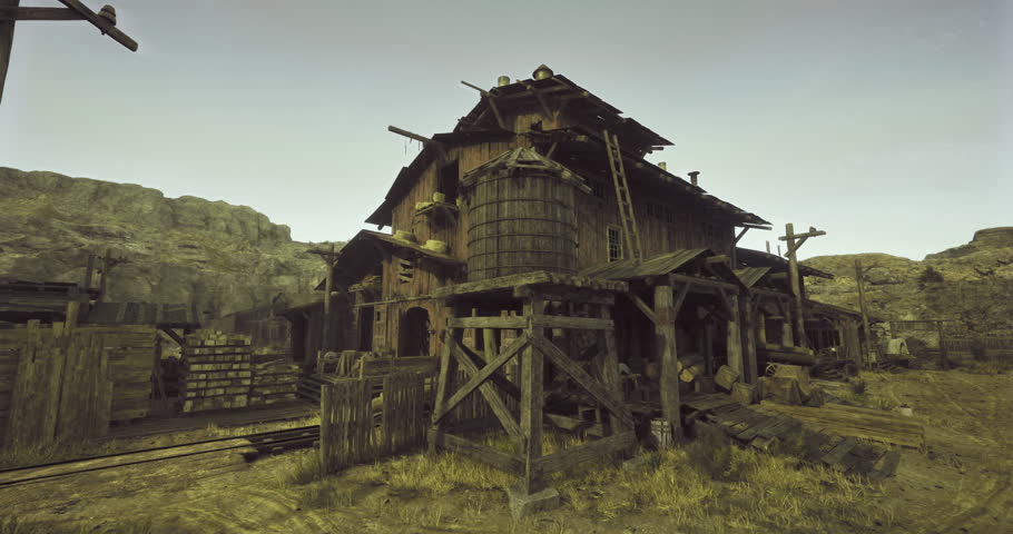 A dilapidated wooden building stands amid a deserted mining town, surrounded by wooden crates and rustic materials during the fading light of dusk.