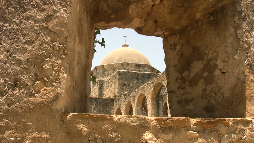 Video of the dome and cross of Mission San Jose church in San Antonio, Texas. View through old rock window. Plants blowing in wind. Don Despain of Rekindle Photo.