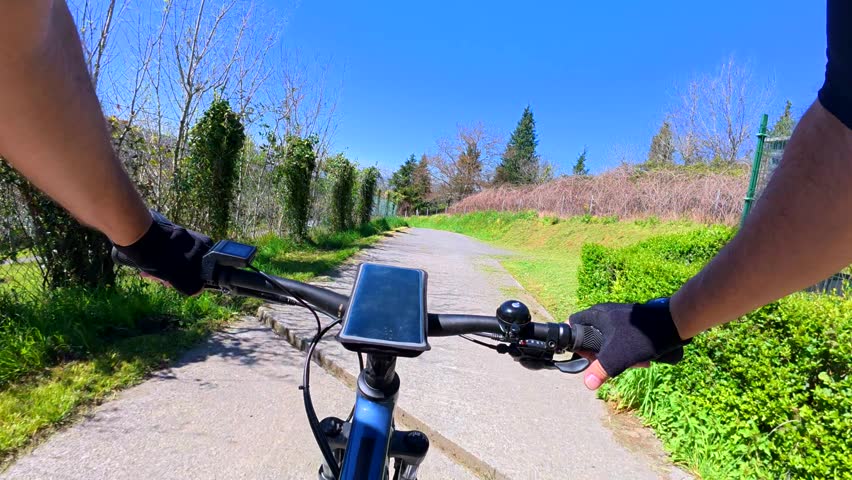 E-bike rider cruising along scenic country road on bright summer day, experiencing landscape through first-person perspective while enjoying outdoor cycling adventure