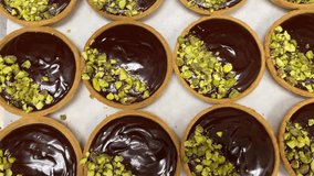 Chocolate pistachio tart, featuring a glossy chocolate ganache filling over a crisp, buttery tart crust, garnished with crushed pistachios for a delightful crunch.  - Powered by Shutterstock - Get 15% off with code: PIKWIZARD15