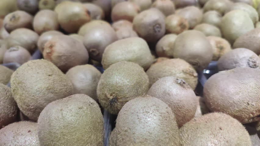 Pile of New Crop Fresh Kiwi Stacked on Market Counter Footage.