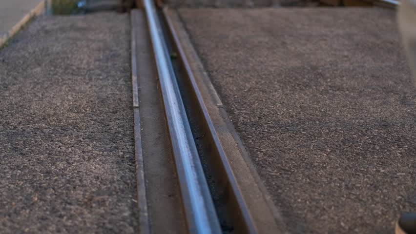 Tourist strolling along scenic railroad tracks. Tourist in jeans and sneakers walks along a railroad track, enjoying a sunny day. The scene captures the essence of travel and adventure