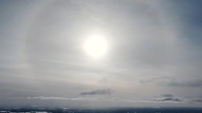 Wide overview of glowing ball of light descending in sky with circular ring as clouds pass in air - Powered by Shutterstock - Get 15% off with code: PIKWIZARD15