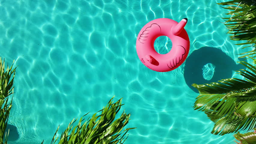 Top-down view of a vibrant tropical swimming pool with a pink inflatable float, surrounded by lush palm trees on a sunny summer day, evoking a serene, relaxing, and refreshing vacation atmosphere.