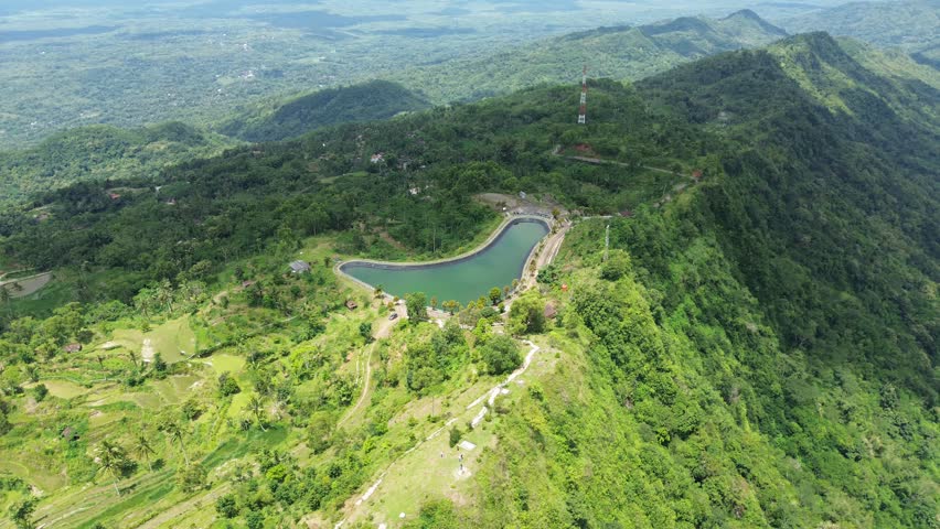 Aerial Video View of Serene Hillside Pond and Lush Greenery