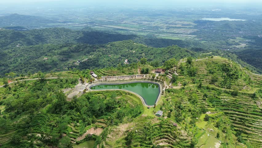 Aerial Video View of Serene Hillside Pond and Lush Greenery