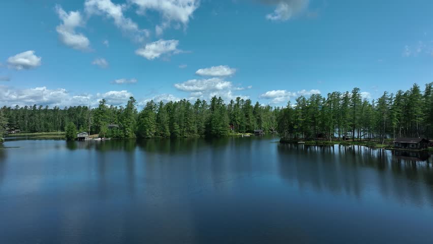 Drone dolly shot taken over Rainbow Lake in the Adirondack Mountains revealing the High Peaks of the range.
