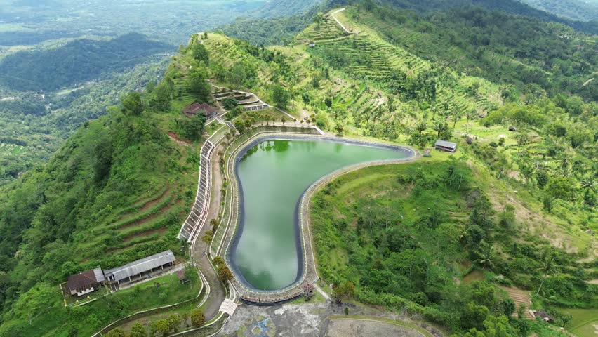 Aerial Video View of Serene Hillside Pond and Lush Greenery