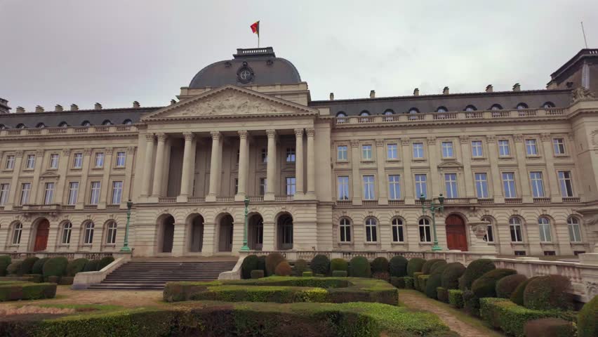 Front view of Royal Palace of Brussels with Belgian flag on cloudy day