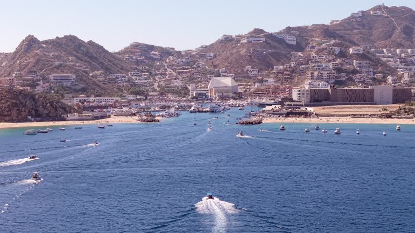 The Cabo San Lucas, Mexico marina and cruise port harbor - ascending aerial looking towards the scenic landscape from the sea
