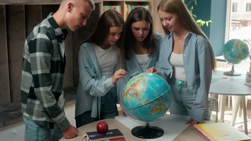 Caucasian teenagers students pupils girls boy guy females women teens in school university academy library studying education together looking for country point search on globe layout geography lesson