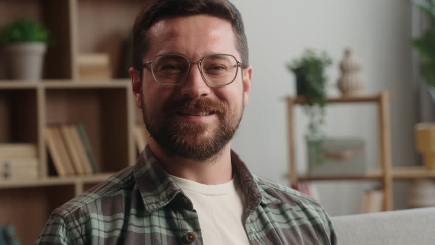 Portrait happy smiling carefree positive headshot Caucasian man male bearded guy in glasses health homeowner in own apartment smile looking at camera relaxing at home loan mortgage insurance satisfied