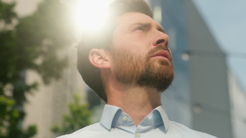 Close-up middle-aged 40s male employer investment entrepreneur adult Caucasian bearded man business guy businessman serious calm peace in city portrait sun outdoors looking at sky thinking job startup