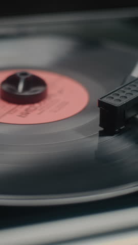 Vinyl Record Spinning On Vintage Turntable. Needle Scratching Grooves, Playing Classic Music or Analog Sound on Vinyl Record Player. Retro Sound System with Nostalgic Aesthetic. Macro Vertical Shot.
