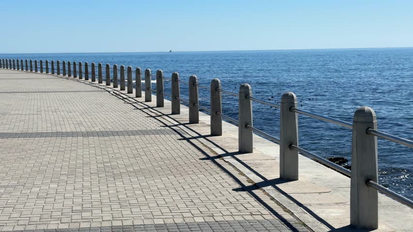Wider symmetrical shot of the Sea Point Promenade on a late summer afternoon.