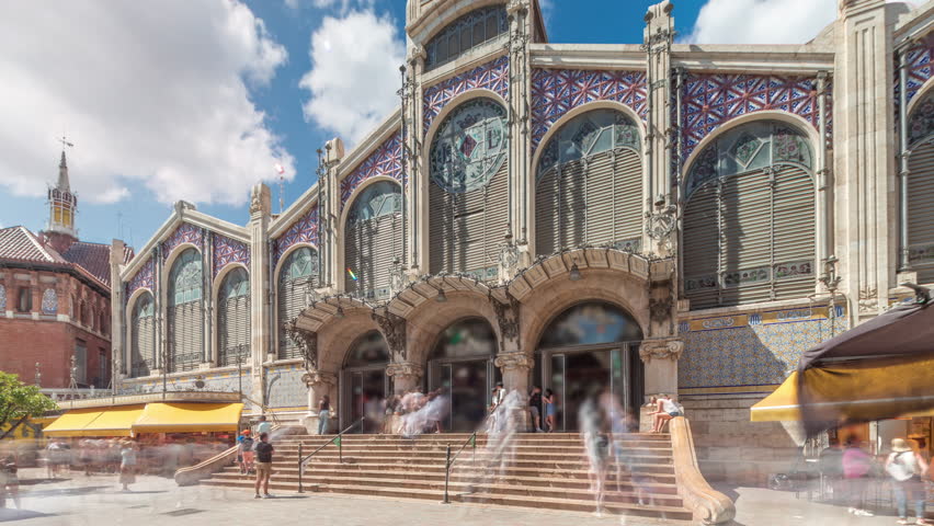 Valencia Central Market timelapse hyperlapse. Historic public market with stunning architecture, stained glass, dome and tile details. Located in Market Square near Santos Juanes Church. Spain