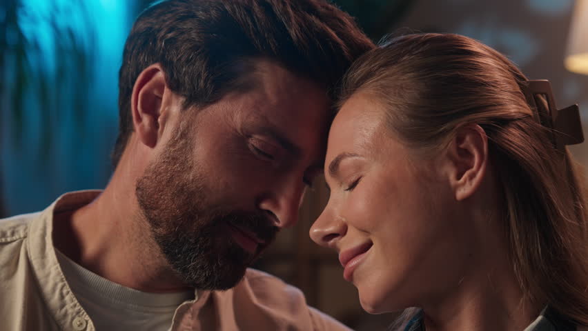 Caucasian married couple woman man girl guy smiling faces bonding wife husband tender love relationship affection cuddle hug romantic night home owners happy family medicine health care loan mortgage