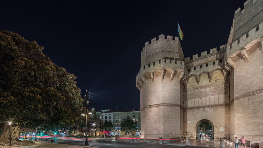 Panorama showing Serrans Towers (Torres de Serranos) night timelapse in Valencia, Spain. A grand medieval gate from the city