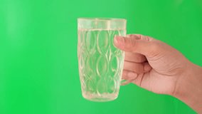 Hand movement holding a clear glass filled with water. Hand gesture on a green screen. - Powered by Shutterstock - Get 15% off with code: PIKWIZARD15