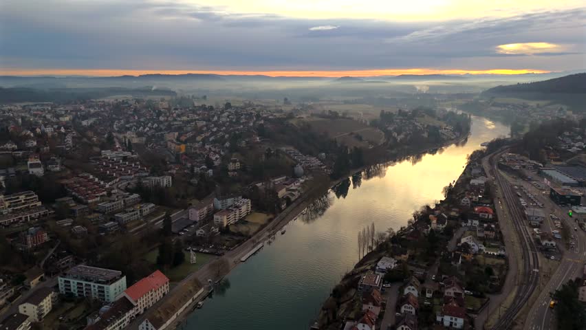 Aerial view of Schaffhausen, Switzerland, with Rhine River winding through historic city at sunrise, rooftops and golden light create breathtaking panorama. Luftaufnahme des Rheins in der Schweiz. 