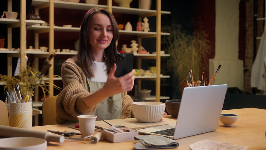 Smiling woman Caucasian girl artist sculptor designer small business owner seller blogger influencer tutorial video mobile phone social media blog vlog handmade craft pottery workshop bowl sale online