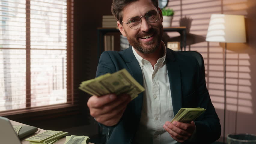 Rich wealthy Caucasian middle-aged investor business man guy male businessman in office counting finance cash salary income looking at camera smiling giving money offer investment bank casino bet