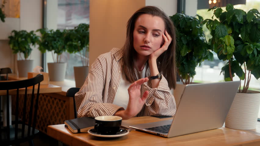 Tired bored overworked depressed working freelance distant work from cafe Caucasian cafeteria visitor woman female business girl businesswoman typing laptop stress boring job unmotivated burnout sad