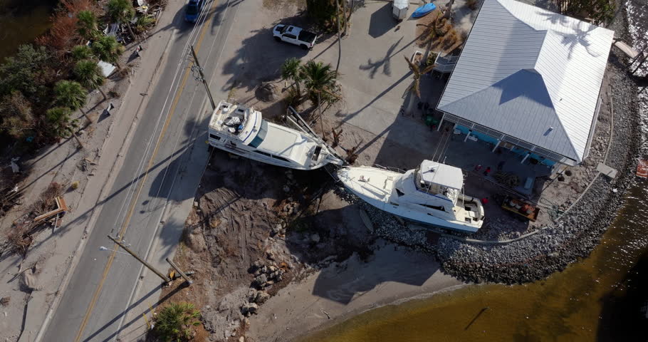 Destroyed sailing yacht capsized on shallow bay waters after hurricane Milton on Manasota Key in Englewood, Florida.